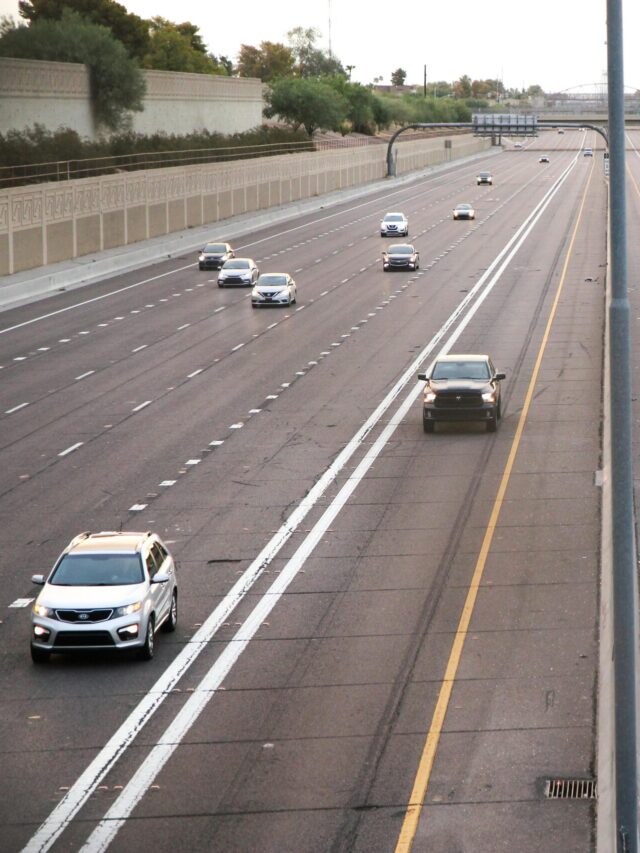 Aerial view of a deserted highway with few cars during dusk, depicting calm traffic conditions.